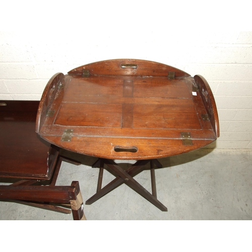 61 - A Victorian mahogany butler's tray, the panelled tray with brass hinged rounded folding gallery, on ... 