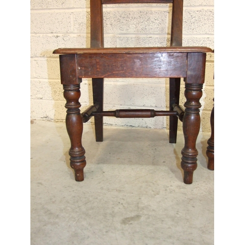 64 - A pair of 19th century oak hall chairs, each with turned spindle back and solid seat, on tapered fro... 