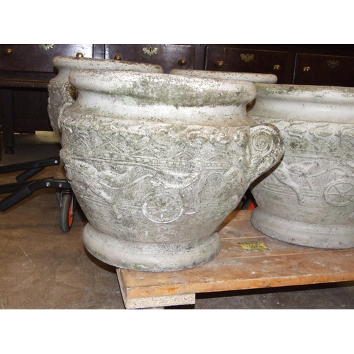 69 - A set of four cast concrete planters of circular form, decorated with chariots and classical buildin... 