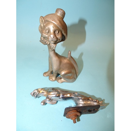 533 - A metal car mascot in the form of a seated smiling cat, wearing a bonnet tied with a bow under its c... 