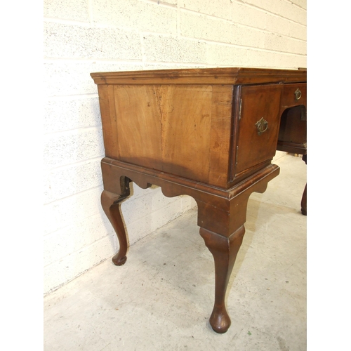 20 - An 18th century walnut feather-banded lowboy, having a central drawer and two small cupboards, on ca... 