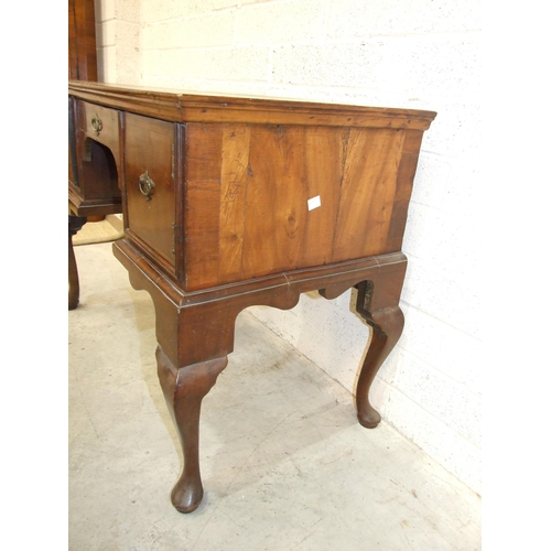 20 - An 18th century walnut feather-banded lowboy, having a central drawer and two small cupboards, on ca... 