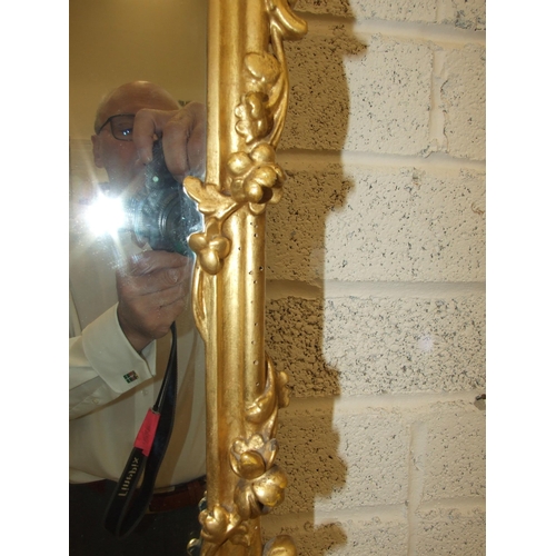 105 - A gilt wood wall mirror with carved foliate frame enclosing the later mirror plate, 75 x 62cm, (old ... 