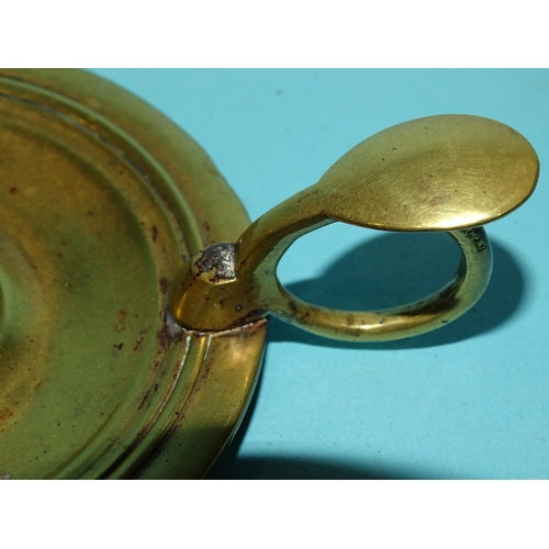 115 - An 18th century brass chamberstick, the circular base with early screw-mounted sconce and finger loo... 