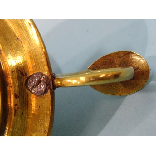 115 - An 18th century brass chamberstick, the circular base with early screw-mounted sconce and finger loo... 