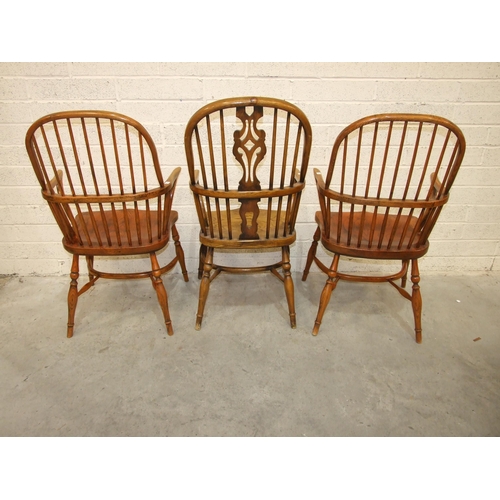 15 - A pair of elm and beech comb-back Windsor chairs with crinoline stretchers and turned legs, (reddish... 