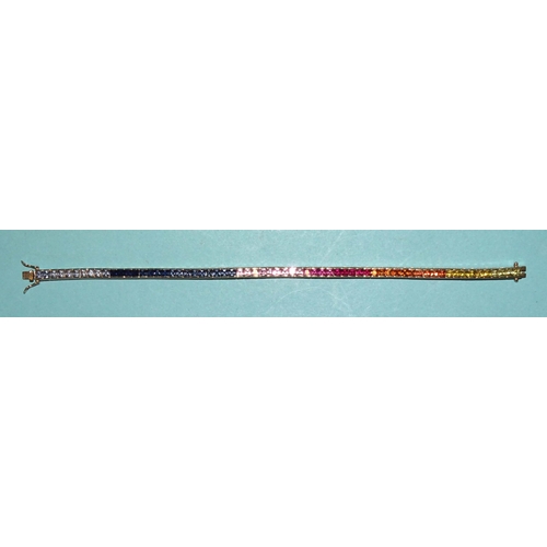 232 - A rainbow sapphire tennis bracelet set a total of sixty-five scissor-cut fancy colour sapphires in g... 