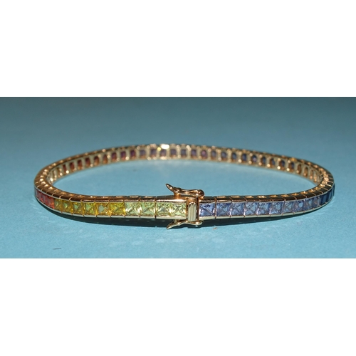 232 - A rainbow sapphire tennis bracelet set a total of sixty-five scissor-cut fancy colour sapphires in g... 