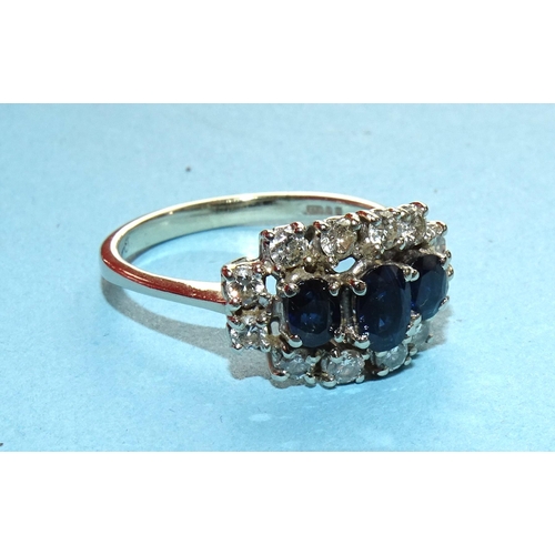 274 - A sapphire and diamond cluster ring claw-set three oval sapphires within border of twelve brilliant-... 