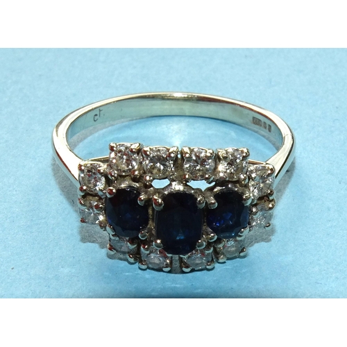 274 - A sapphire and diamond cluster ring claw-set three oval sapphires within border of twelve brilliant-... 
