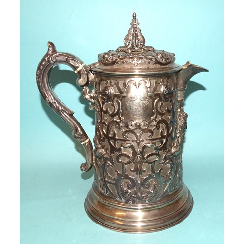 A Victorian Scottish embossed jug decorated in the Cellini taste, with finialled lid, matted spout and leaf-capped handle with ivory insulators (*ivory exemption certificate number PXEKRE17), on circular stepped base, the body decorated with fruit, masks and ram's heads, maker John Russell, Glasgow 1860, 26cm high, ___35oz.