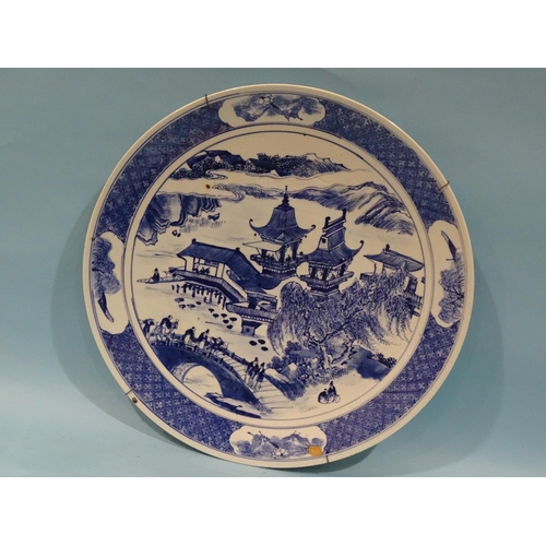 92 - A late-19th century large Chinese charger decorated with blue and white pagoda, figures and scenery,... 