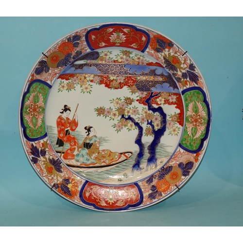 93 - A large Japanese wall charger decorated with figures in a boat, in Imari colours, 46cm diameter and ... 