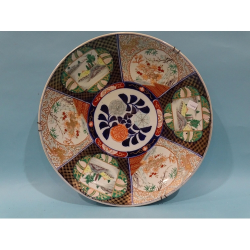 93 - A large Japanese wall charger decorated with figures in a boat, in Imari colours, 46cm diameter and ... 