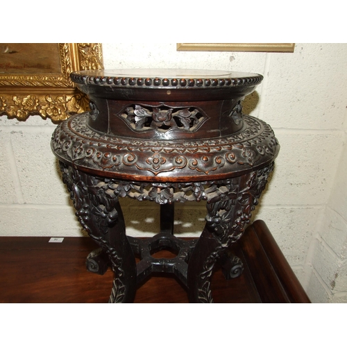 6 - A Chinese carved hardwood plant stand with raised inset marble top, on five shaped and carved legs, ... 