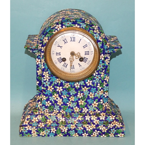33 - A ceramic mantel clock decorated with enamelled flower heads and leaves, the white enamel dial with ... 