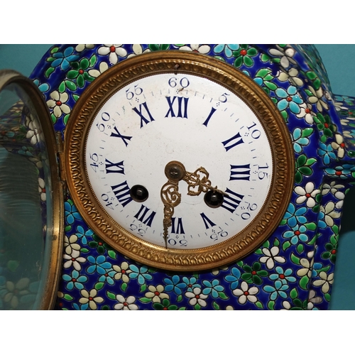 33 - A ceramic mantel clock decorated with enamelled flower heads and leaves, the white enamel dial with ... 
