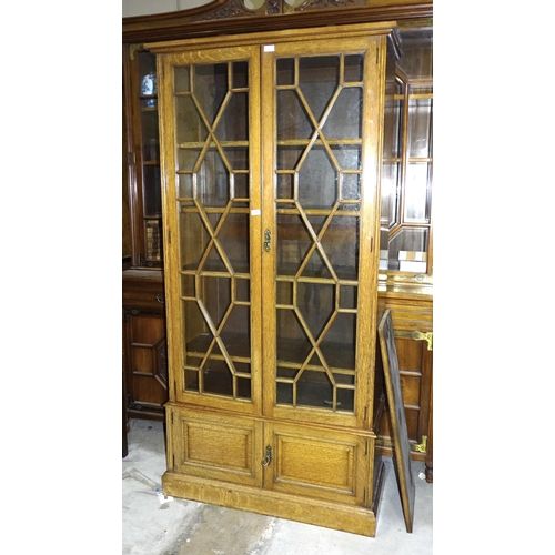 5 - A 20th century oak two-door bookcase having a pair of astragal-glazed doors above two small panelled... 