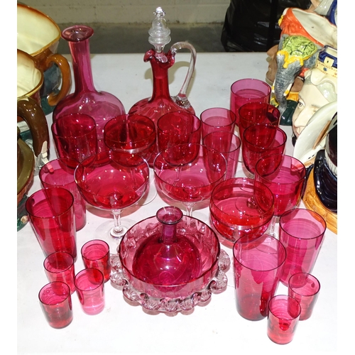 131 - A cranberry glass decanter, 27cm high, a circular frilled bowl and a collection of cranberry glasses... 