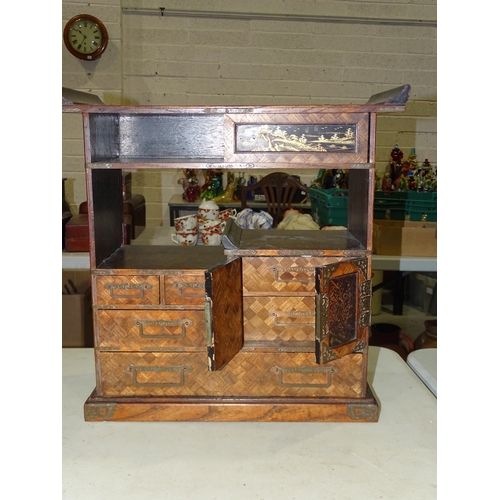 124 - An early-20th century Japanese parquetry collector's chest with an arrangement of drawers, shelves a... 