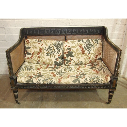 104 - A Regency caned Bergère settee with painted frame, on removeable turned legs with castors, 129cm wid... 