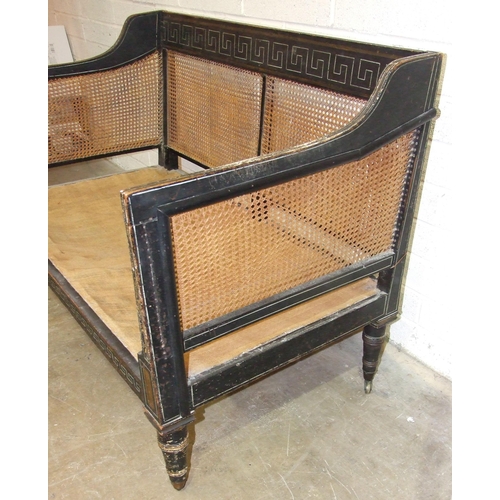 104 - A Regency caned Bergère settee with painted frame, on removeable turned legs with castors, 129cm wid... 