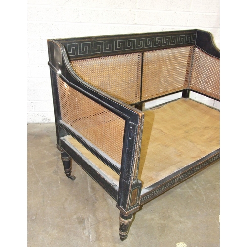 104 - A Regency caned Bergère settee with painted frame, on removeable turned legs with castors, 129cm wid... 