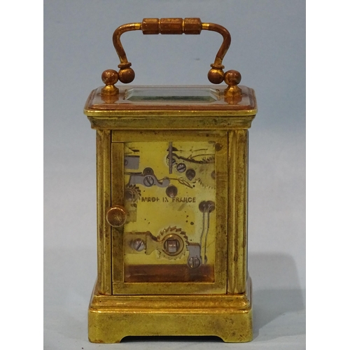 126 - A late-19th/early-20th century brass miniature carriage alarm clock, the white enamel face with dial... 