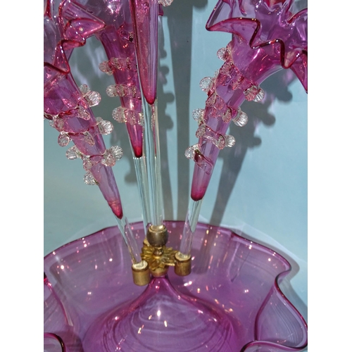 140 - A late-19th century cranberry glass epergne, the central trumpet vase flanked by three further vases... 