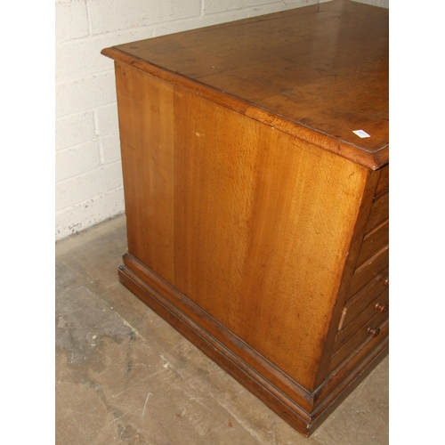 67 - An Edwardian oak plan chest of seven drop-down-fronted drawers, on plinth base and panelled back, wi... 