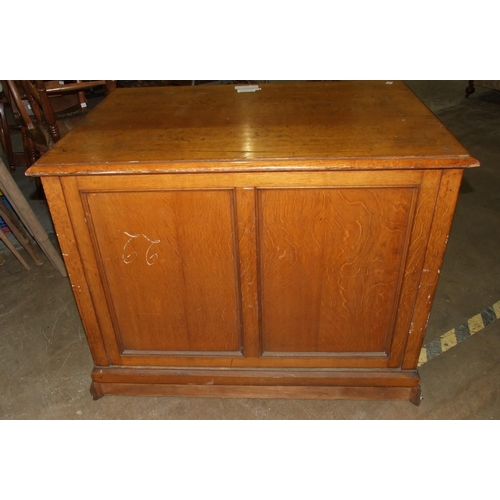 67 - An Edwardian oak plan chest of seven drop-down-fronted drawers, on plinth base and panelled back, wi... 