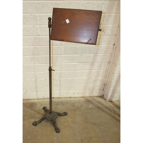 92 - A Victorian cast-iron adjustable music stand, the brass arm with oak stand labelled 