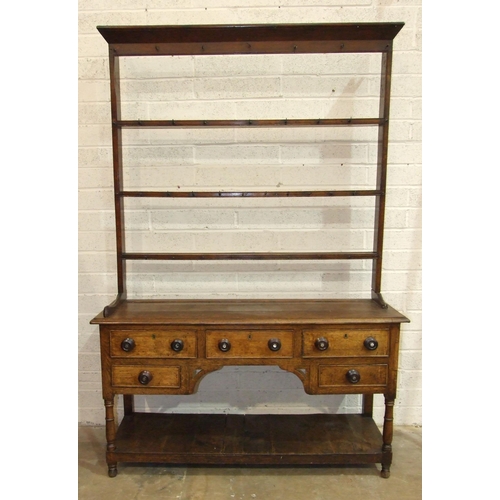 93 - An antique oak Welsh dresser, the plate rack with some original cup hooks, the base fitted with an a... 