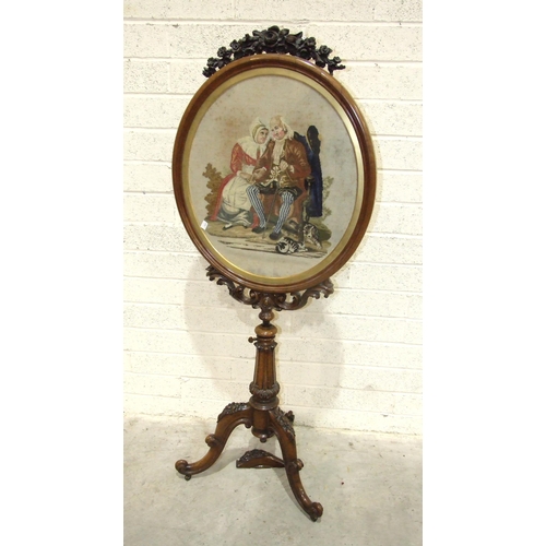 78 - A William IV rosewood tripod fire screen with oval needlework panel depicting two figures seated on ... 