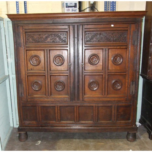 109 - A large antique oak two-door food cupboard, with later cornice above a pair of carved panelled doors... 