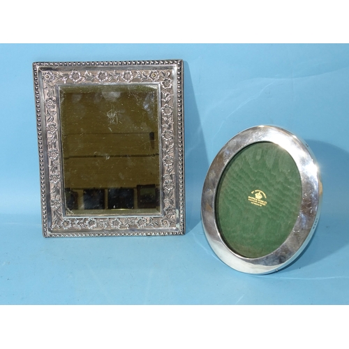 469 - A late Victorian silver framed rectangular wall mirror, the border with embossed floral decoration, ... 