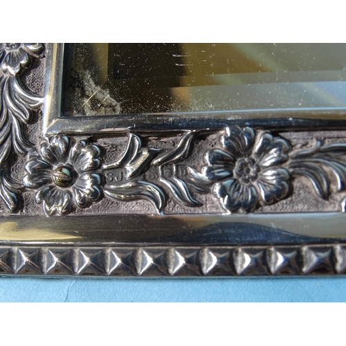 469 - A late Victorian silver framed rectangular wall mirror, the border with embossed floral decoration, ... 