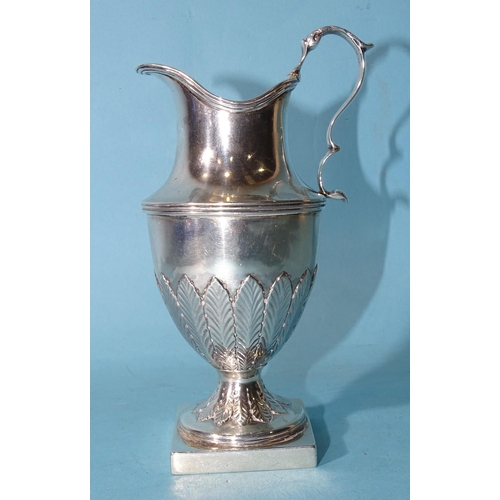 478 - A George III silver urn shape pedestal cream jug on square base with scrolling handle and leaf decor... 