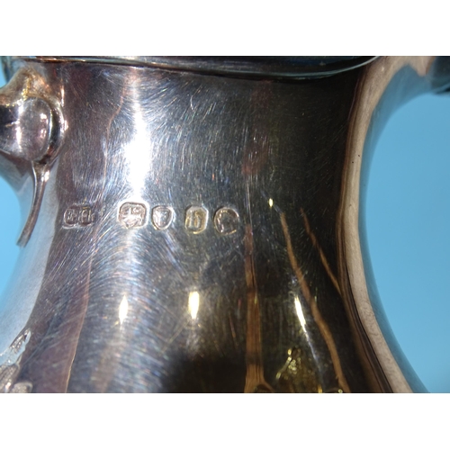 483 - A Victorian silver pear-shaped chocolate pot, the hinged cover with floral finial, the body with emb... 