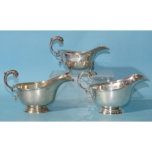 492 - A pair of silver sauce boats, each with leaf-capped C-scroll handle, Harrods Ltd, London 1938 and an... 