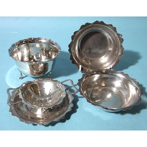 519 - A tea strainer on stand and two shallow bowls, Birmingham 1945 and a damaged three-legged sugar bowl... 