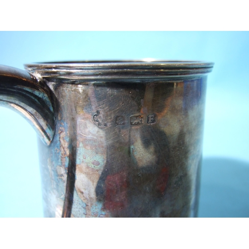 522 - A plain silver tankard with reeded borders, Birmingham 1930, 11cm high, (foot rim bent), ___11oz.... 