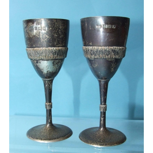 531 - A pair of small modern silver goblets, the bowl and stem with band of bark-effect decoration, on cir... 