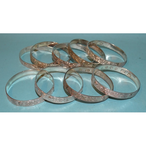 190 - Nine silver bangles with an embossed Celtic snake design, each hallmarked for Gordon H Walker, Edinb... 