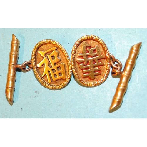 98 - A pair of Chinese 18ct gold cufflinks of oval form, with raised Chinese characters, 10.7g.... 