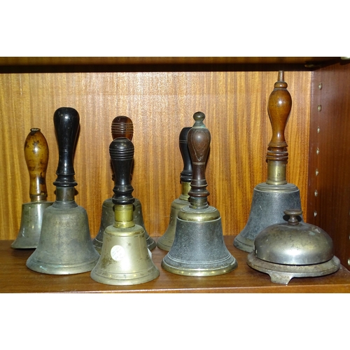 54 - A collection of seven brass hand bells with turned wood handles and a reception bell by Russell and ... 