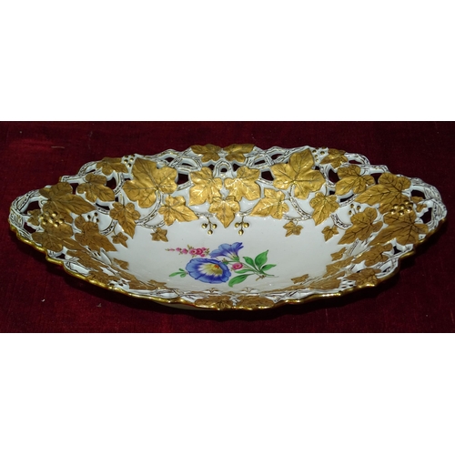 56 - A late-19th century German oval fruit dish, the pierced vine border surrounding a painted spray of f... 