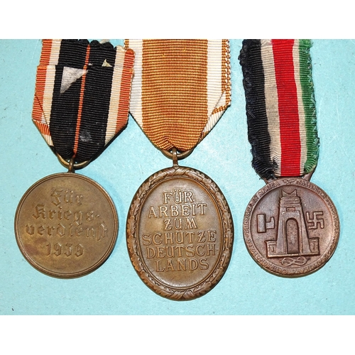 232 - Three German WWII medals: African Campaign, West Wall and Merit, (3).