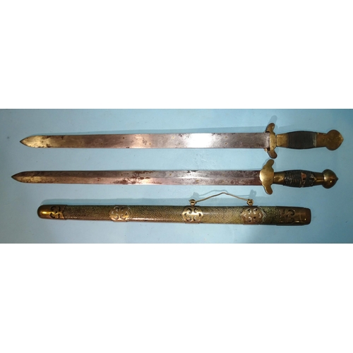 391 - A Chinese double-sword, the 21½'' (54.5cm) blades with string-bound grips, brass-mounted overall, wi... 