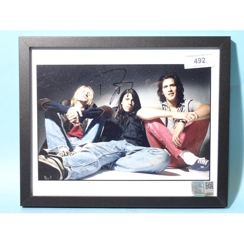 492 - Nirvana, a coloured photograph of the group signed by Dave Grohl, 19 x 24.5cm, with Holland Shier au... 